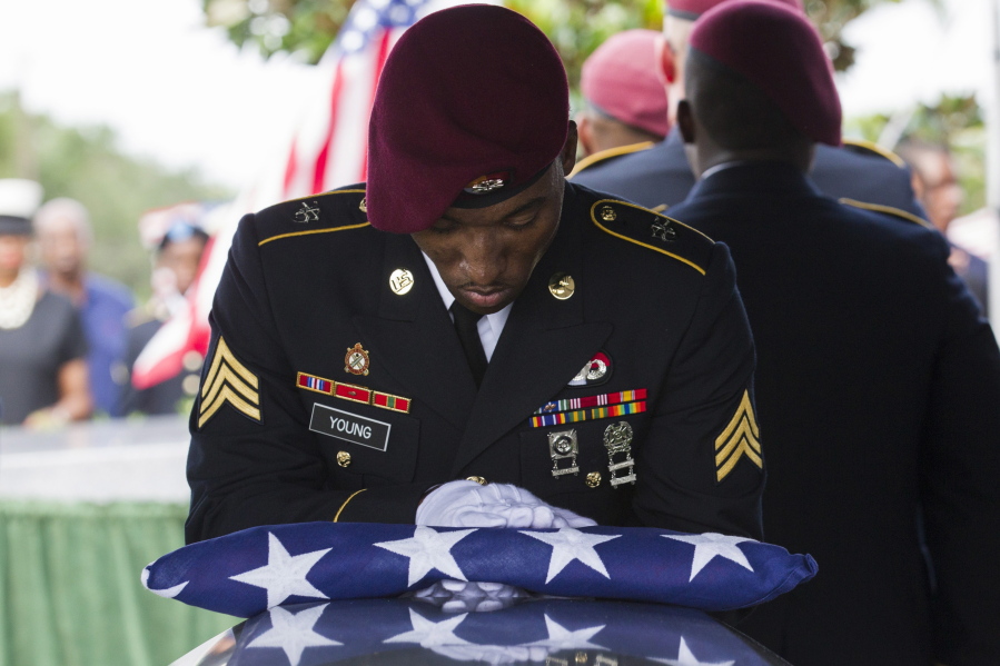 Sgt. Donald Young places a U.S. flag over the casket of Sgt. La David Johnson during his burial service at Fred Hunter's Hollywood Memorial Gardens in Hollywood, Fla., on Saturday, Oct. 21, 2017. Mourners remembered not only a U.S. soldier whose combat death in Africa led to a political fight between President Donald Trump and a Florida congresswoman but his three comrades who died with him. (Matias J.