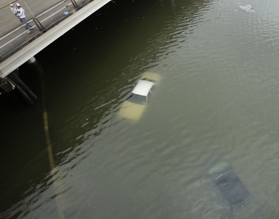 People look at submerged cars on a freeway flooded by Tropical Storm Harvey on Aug. 27, 2017 near downtown Houston, Texas. After Hurricanes Harvey, Irma and Maria blitzed the nation, most Americans think weather disasters are getting more severe and they see global warming’s fingerprints all over them. A new poll by the Associated Press-NORC Center for Public Affairs Research says 68 percent of those surveyed think weather disasters seem to be worsening, compared to 28 percent who think they are staying the same and only 4 percent who say they are less severe.