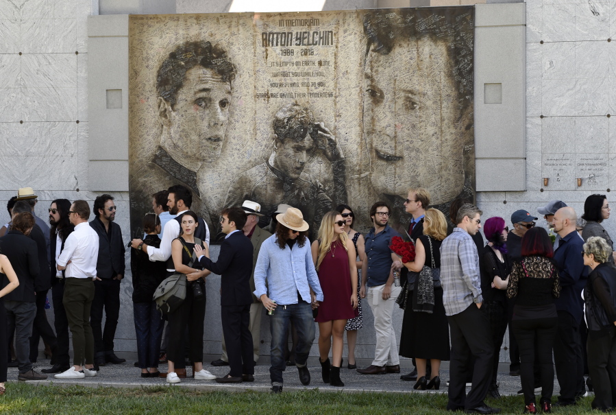 Guests gather beneath a mural of the late actor Anton Yelchin created by fans at a “Star Trek” convention, during a life celebration and statue unveiling for Yelchin at Hollywood Forever Cemetery on Sunday, Oct. 8, 2017, in Los Angeles.