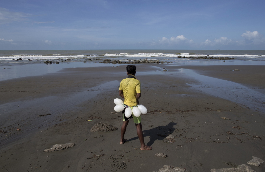 A fisherman adjusts his waist floats near the site where a boat carrying Rohingya refugees capsized on Sept. 28 at Inani beach, Cox’s Bazar, Bangladesh. The boat capsized just 1,000 feet (300 meters) from shore, taking the lives of at least 50 people, most of them children, in the deadliest tragedy of its kind since the crisis exploded in late August. They were part of the largest human exodus in Asia since the Vietnam War, a colossal tide of more than 500,000 Rohingya Muslims whose homes had been torched by Buddhist mobs and soldiers.