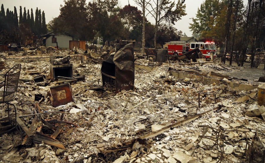 Firefighters drive through the Coffey Park area of Santa Rosa, Calif., looking for hotspots on Tuesday. An onslaught of wildfires across a wide swath of Northern California broke out almost simultaneously then grew exponentially, swallowing up properties from wineries to trailer parks and tearing through both tiny rural towns and urban subdivisions.