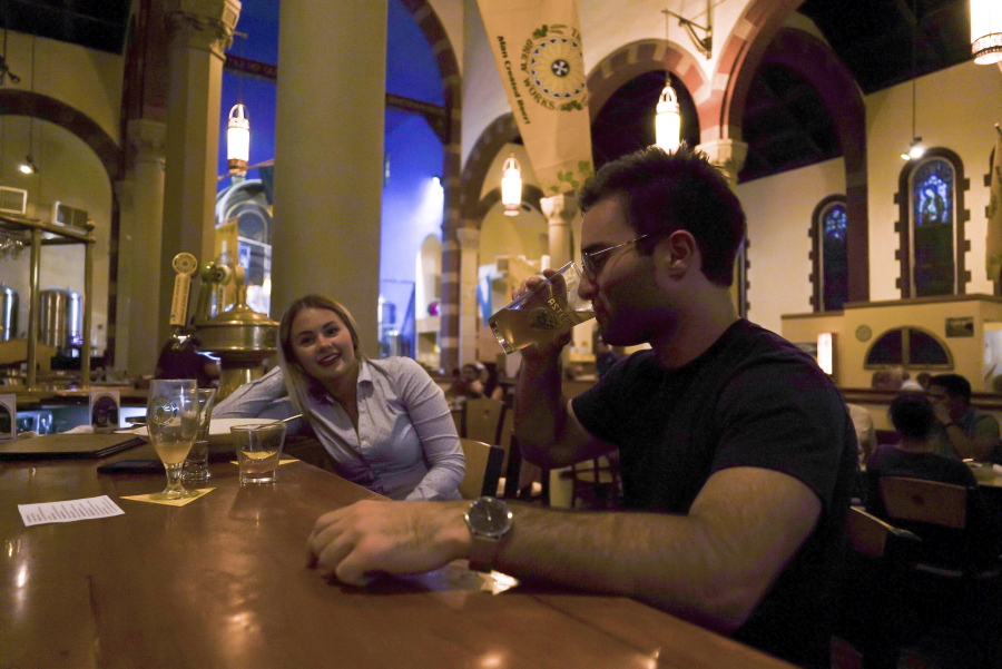 Jesse Hulien, right, drinks a beer as Molly Hartman, left, looks on, at the Church Brew Works, a former church renovated into a brewery, in Pittsburgh. Breweries opening in renovated churches are winning fans but earning disapproval from clergy and worshippers across the U.S.