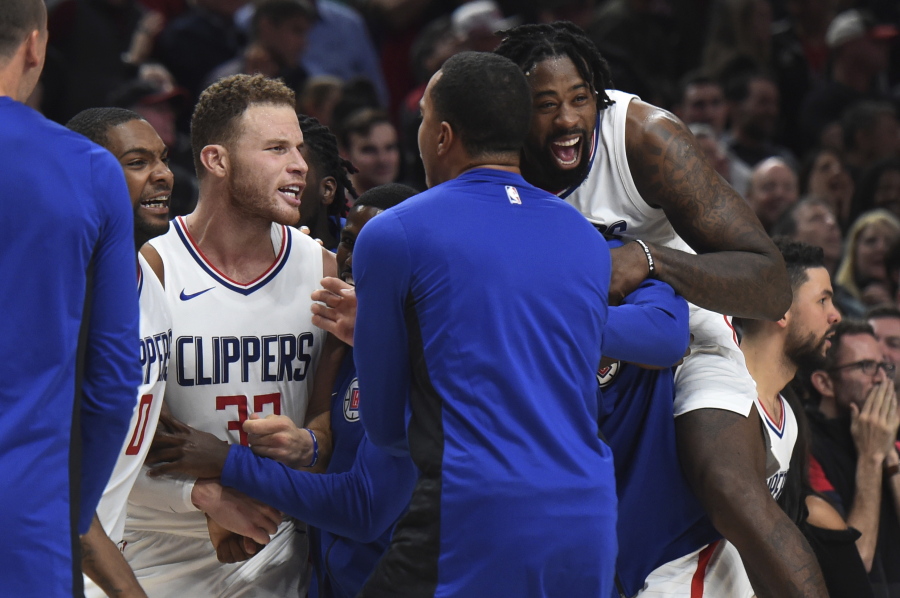 Los Angeles Clippers forward Blake Griffin is mobbed by his teammates after hit the game winning shot during the fourth quarter of an NBA basketball game against the Portland Trail Blazers in Portland, Ore., Thursday, Oct. 26, 2017. The Clippers won 104-103.