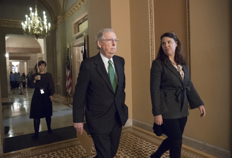 Senate Majority Leader Mitch McConnell, R-Ky., joined at right by Secretary for the Majority Laura Dove, walks from his office to the chamber for the start of the legislative day, at the Capitol in Washington on Tuesday. (AP Photo/J.