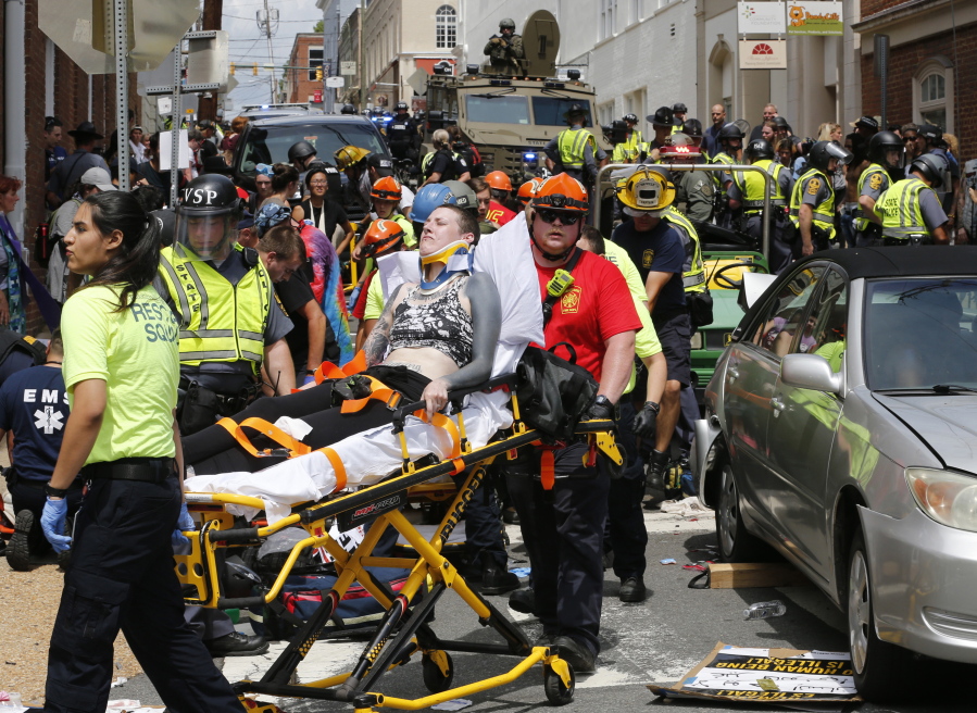 Rescue personnel help injured people who were hit when a car ran into a large group of protesters Aug. 12 after a white nationalist rally in Charlottesville, Va. Attacks this summer on counter-protesters in Charlottesville, Virginia, and an empty Air Force recruiting station in Oklahoma had the hallmarks of terrorist attacks. But they weren’t prosecuted as such.