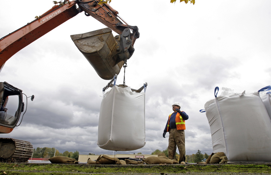 A work crew places large sacks of sand on top of a levy along the Green River in the Seattle suburb of Tukwila on Oct. 30, 2009. In early 2009, heavy rains and melting snow caused flooding in parts of Washington, leading to a leak in the earthen abutment of the Howard Hanson Dam. Officials in King County and several cities placed giant sandbags atop downstream levees, erected flood guards around facilities such as a jail and sewage treatment plant, and temporarily relocated the county election office. “FEMA staff told us, ‘We understand why you did what you did, and it was a reasonably prudent thing to protect the public,’” said Mark Isaacson, King County’s wastewater treatment director who at the time led its flood control division.