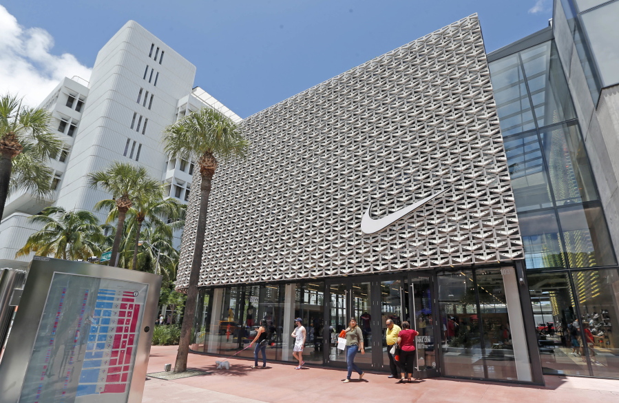 Shoppers walk out of a Nike store in Miami Beach, Fla.