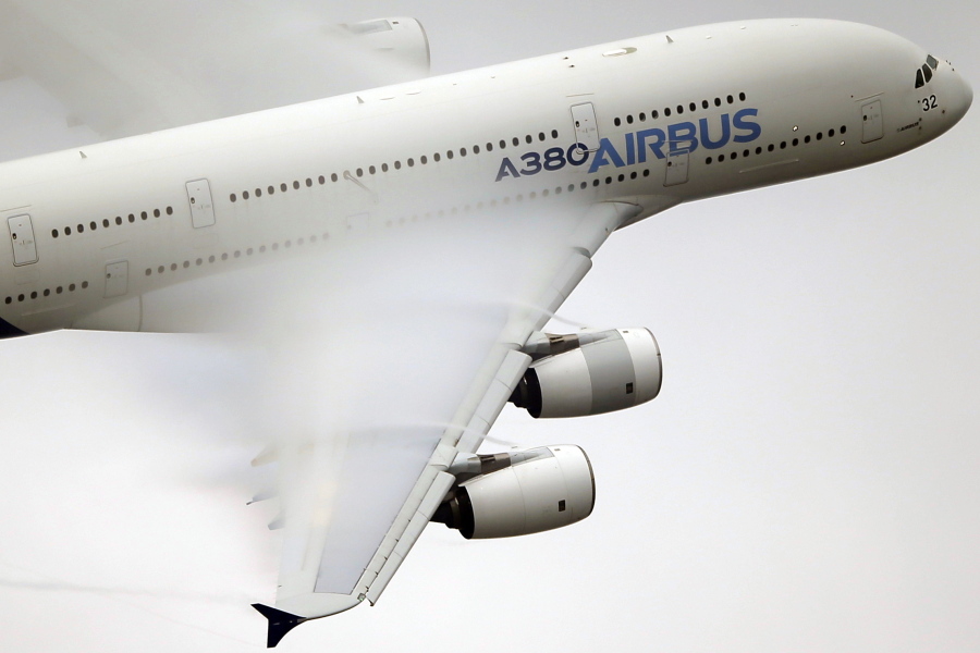 FILE - In this June 18 2015 file photo, vapour forms across the wings of an Airbus A380 as it performs a demonstration flight at the Paris Air Show, Le Bourget airport, north of Paris. Airbus shares have risen thanks to an unusual no-cost deal with Canada’s Bombardier that has angered U.S. rival Boeing.