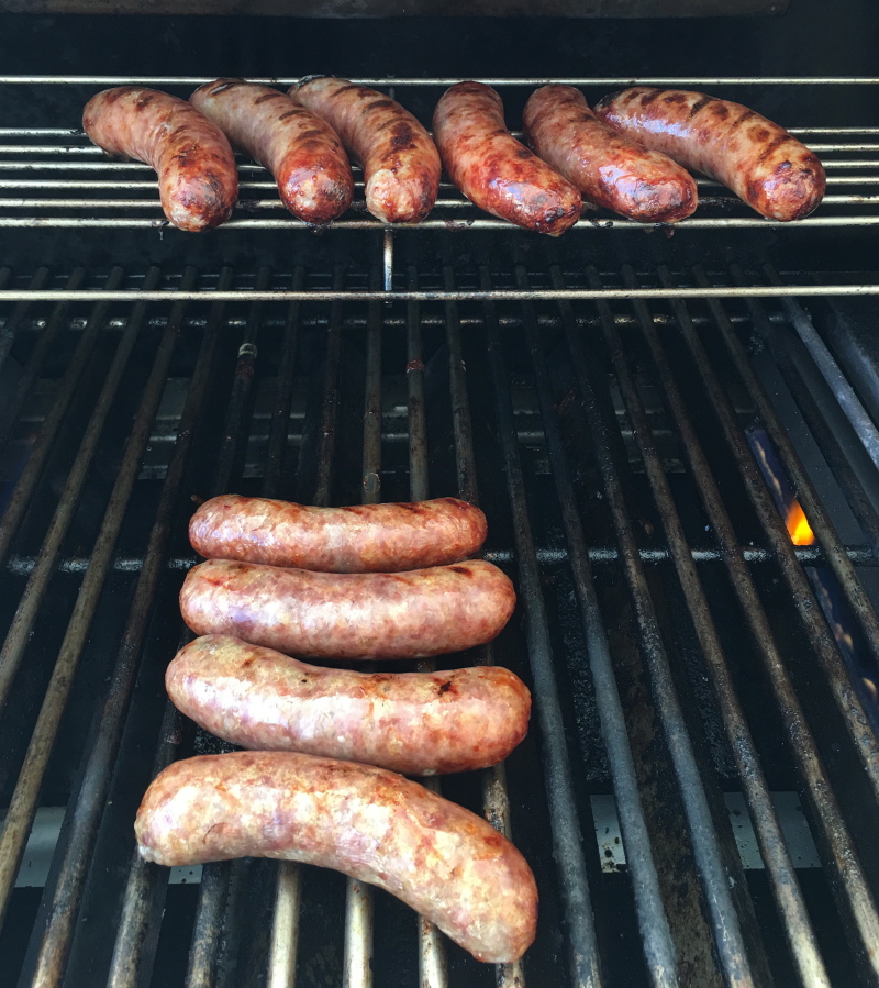 Bratwurst sausages being grilled before simmering in beer in Houston. This dish is from a recipe by Elizabeth Karmel.