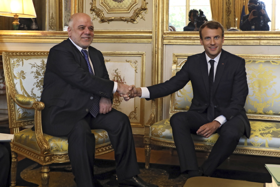 French president Emmanuel Macron, right, shakes hands with Iraqi Prime minister Haider al-Abadi prior to their meeting at the Elysee palace in Paris, on Thursday.
