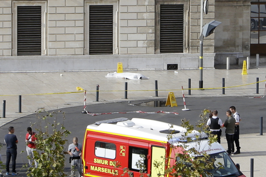 A body lies under a white sheet outside Marseille’s main train station after man with a knife attacked people Sunday, killing two women.