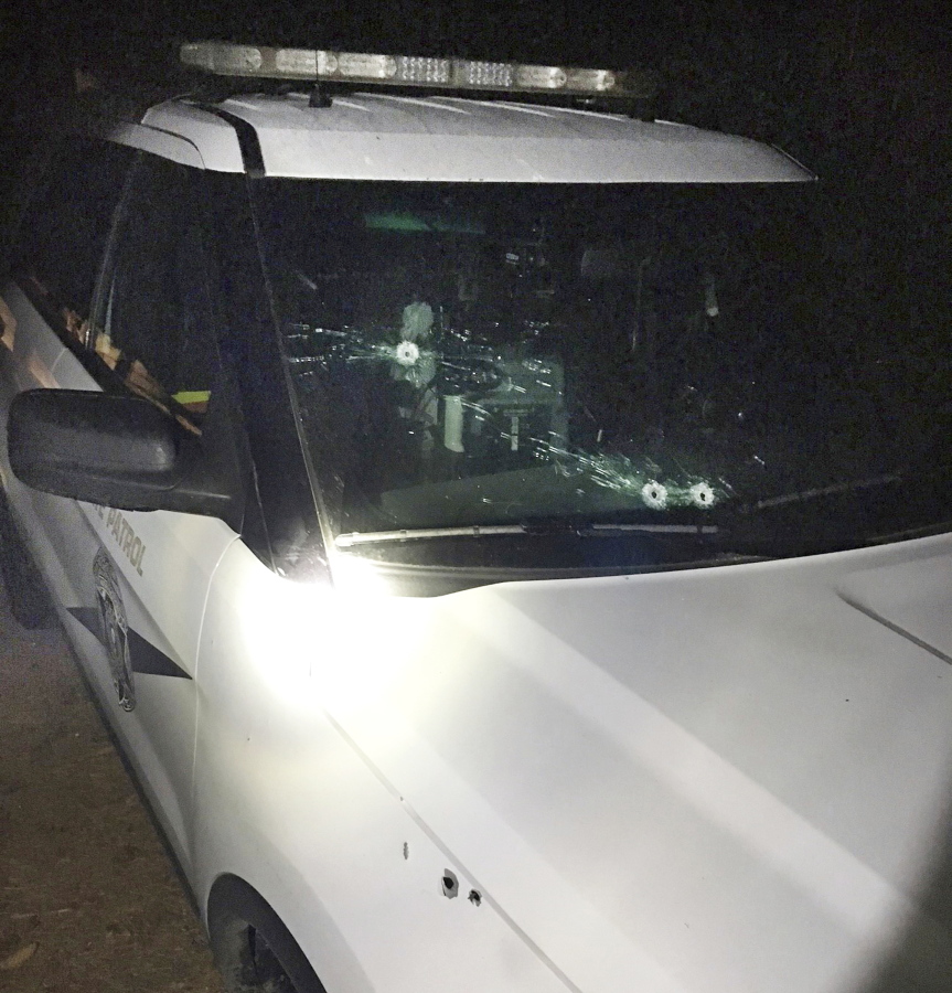A trooper’s cruiser with bullet holes following a shootout with two men in Grandview, Wash., late on Oct. 23, 2017. The State Patrol is looking for two people among the vineyards of south-central Washington after they opened fire on a trooper who tried to pull them over for speeding.