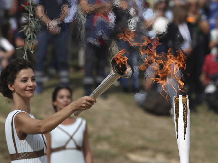 Actress Katerina Lehou as high priestess, passes the Olympic Flame onto a Pyeongchang torch bearer after it was lit from the sun’s rays, during the final dress rehearsal for the lighting of the Olympic flame at Ancient Olympia, southwestern Greece on Monday. The flame will be transported by torch relay to Pyeongchang, South Korea, which will host the Feb. 9-25, 2018 Winter Olympics.