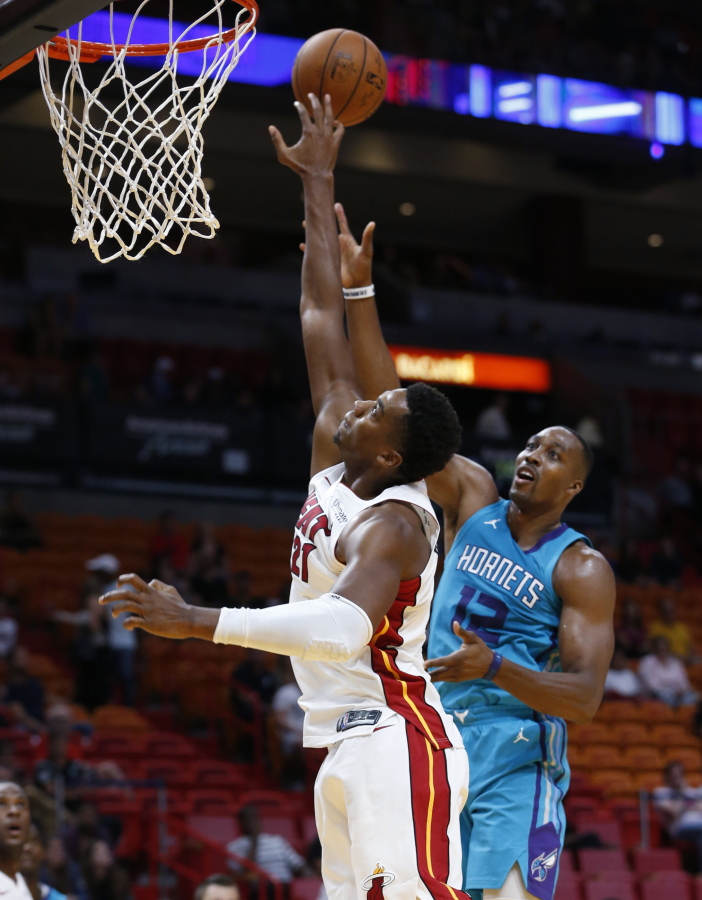Miami Heat center Hassan Whiteside (21) blocks a shot from Charlotte Hornets center Dwight Howard (12) during the first half of an NBA preseason basketball game, Monday, Oct. 9, 2017, in Miami.