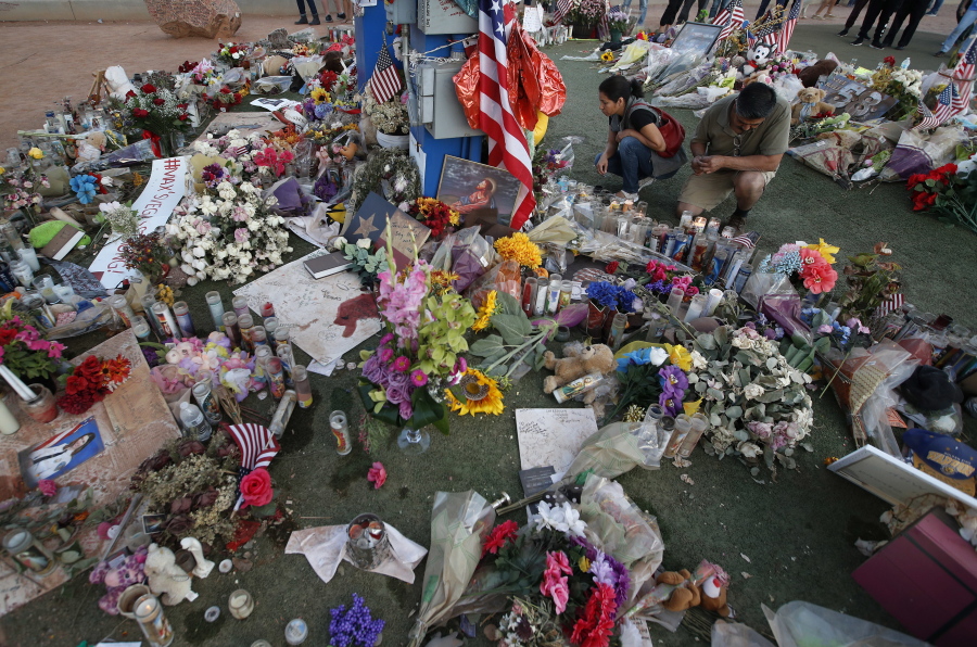 People visit a makeshift memorial for victims of the mass shooting in Las Vegas, Monday, Oct. 16, 2017, in Las Vegas.