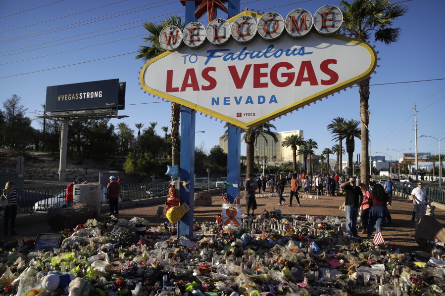 Flowers, candles and other items surround the famous Las Vegas sign at a makeshift memorial for victims of a mass shooting Monday in Las Vegas. Stephen Paddock opened fire on an outdoor country music concert killing dozens and injuring hundreds.