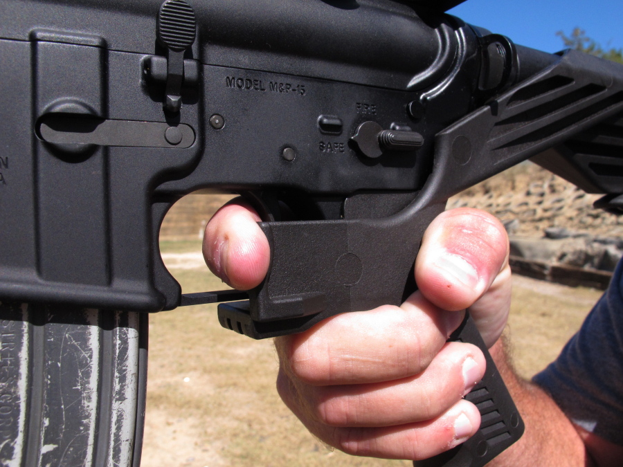 Shooting instructor Frankie McRae demonstrates the grip on an AR-15 rifle fitted with a “bump stock” at his 37 PSR Gun Club in Bunnlevel, N.C. The Brady Center to Prevent Gun Violence filed the lawsuit on Friday against the makers and sellers of “bump stocks,” which use the recoil of a semiautomatic rifle to let the finger “bump” the trigger, allowing the weapon to fire continuously. The devices were used by Stephen Paddock when he opened fire on a country music festival in Las Vegas, killing dozens of people. (AP Photo/Allen G.