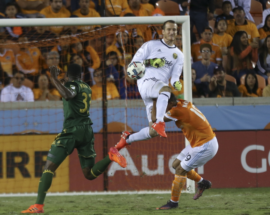 Portland Timbers goalkeeper Jeff Attinella (1) collides with Houston Dynamo forward Mauro Manotas (19) as he comes out to get the ball away from Manotas during the MLS Western Conference semifinal soccer match Monday, Oct. 30, 2017, in Houston.