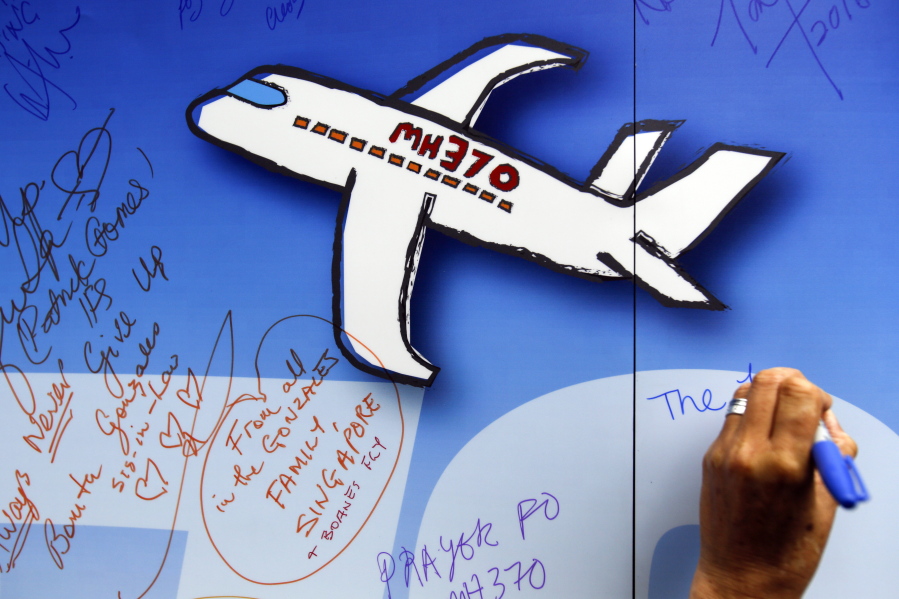 FILE - In this March 6, 2016, file photo, well wishes are written on a wall of hope during a remembrance event for the ill fated Malaysia Airlines Flight 370 in Kuala Lumpur, Malaysia. A report into the search for Flight 370 says the continuing mystery over the fate of the plane and the 239 people on board is ‘Äúalmost inconceivable.’Äù But the Australian Transport Safety Bureau’Äôs report on the search, abandoned in January, concedes that authorities are no closer to knowing the reasons for the plane’Äôs disappearance, or its exact location.