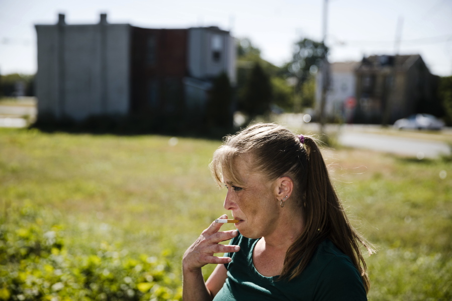 Denise Brown who is addicted to heroin, smokes as after she picked up a package of necessities from the Camden Area Health Education Center Mobile Health Van parked in vacant lot in Camden, N.J. Advocates say the shuttering of a needle exchange in Camden has left many in a city notorious for heroin without a resource that has handed out thousands of sterile syringes.