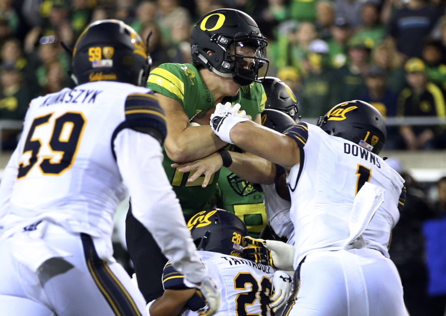 Oregon quarterback Justin Herbert, center, drives into the end zone for a touchdown during the first quarter against California on Saturday. Both quarterback Justin Herbert and running back Royce Freeman were injured in the victory.