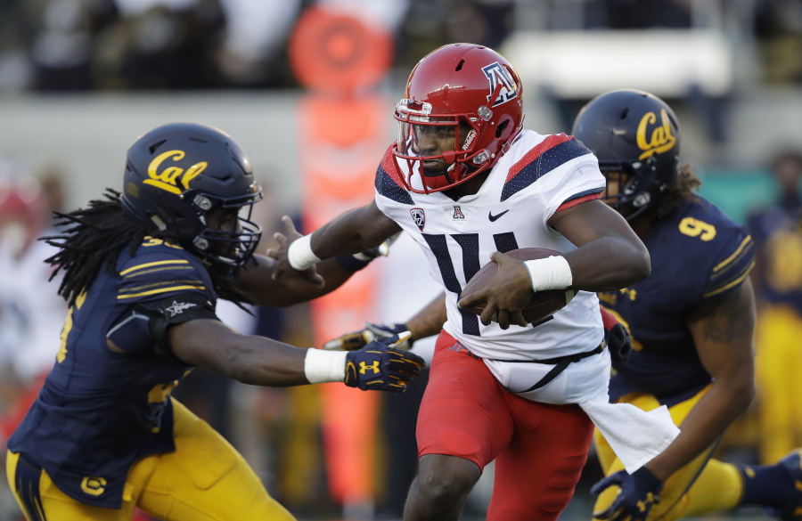 Arizona quarterback Khalil Tate, center, runs for a touchdown past California linebacker Alex Funches, left, during the first half of an NCAA college football game in Berkeley, Calif. Arizona’s quarterback situation was resolved three games ago when Tate took over as starter. Other Pac-12 teams haven’t had the same success in navigating mid-season QB quandaries. Injuries have impacted Oregon and Oregon State at the position.