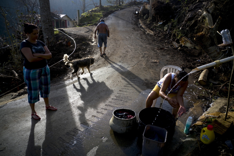 A woman washes clothes with water piped from a mountain creek Oct. 1 in Morovis, Puerto Rico.