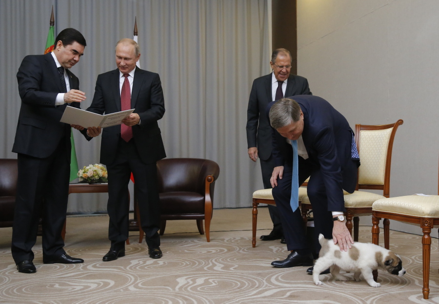 Turkmenistan’s President Gurbanguly Berdymukhamedov, left, shows documents of presented by his puppy to Russian President Vladimir Putin, second right, as Foreign Minister Sergey Lavrov, second right, Presidential foreign affairs adviser Yuri Ushakov, right, play with the puppy during their meeting in the Bocharov Ruchei residence in the Black Sea resort of Sochi, Russia, Wednesday. The presidents met at the sidelines of a summit of leaders of ex-Soviet nations in Sochi.