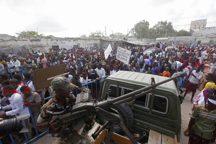 A Somali soldier sits with a machine gun on top a truck as protesters march with placards reading “Out Al Shabab” near the scene of Saturday’s massive truck bomb attack in Mogadishu, Somalia, Wednesday, Oct. 18, 2017. Thousands of people took to the streets of Somalia’s capital Wednesday in a show of defiance after the country’s deadliest attack, as two people were arrested in connection with Saturday’s massive truck bombing that killed more than 300.