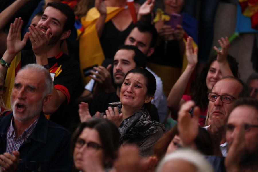 Pro-independence supporters react during a rally as they watch Catalan President Carles Puigdemont speaking in parliament, on a giant screen in in Barcelona, Spain, Tuesday. Puigdemont said the region remained committed to independence but said it should follow dialogue with the government in Madrid.