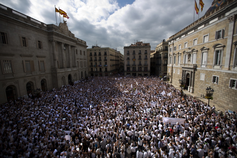 People gather during a protest in favor of talks and dialogue in Sant Jaume square in Barcelona, Spain, Saturday Oct. 7, 2017. Thousands gathered at simultaneous rallies in Madrid and Barcelona in a call for dialogue amid a political crisis caused by Catalonia’s secession push.