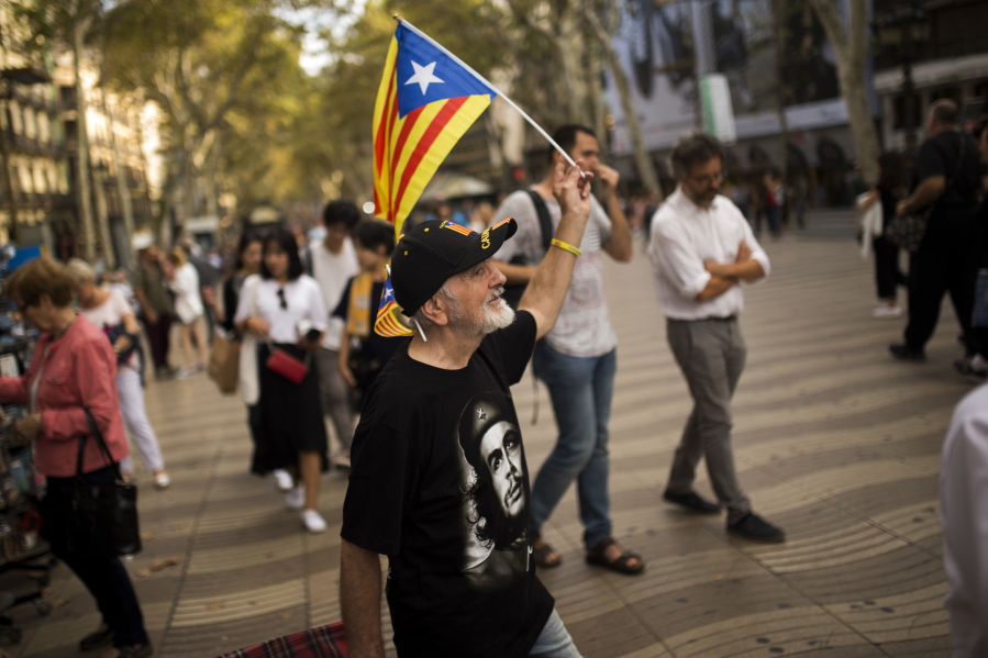 A man waves an “estelada”, or Catalonia independence flag, as he walks along the Ramblas in Barcelona, on Wednesday. Catalonia’s regional government is mulling when to declare the region’s independence from Spain in the wake of a disputed referendum that has triggered Spain’s most serious national crisis in decades.