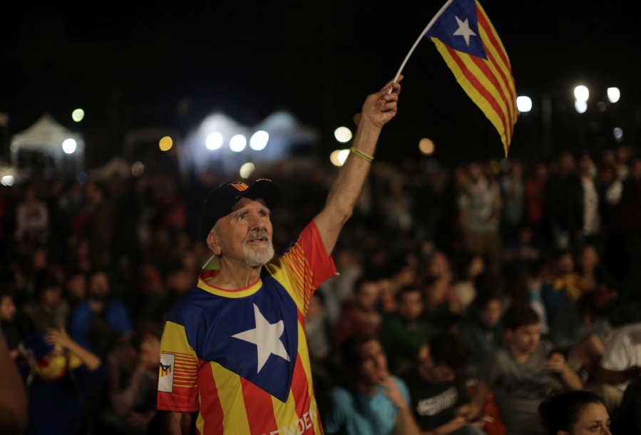 A man waves a “estelada’’ or Catalonia independence flag during a gathering at Plaza Catalonia in Barcelona, Spain, Sunday evening. During the day Spanish riot police smashed their way into polling stations to try to halt a disputed independence referendum and fired rubber bullets at protesters.