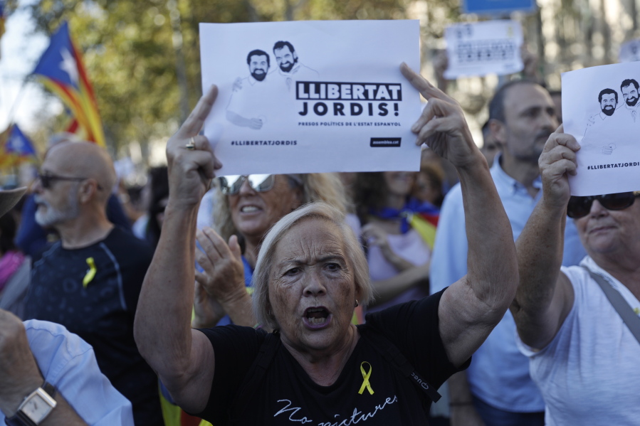 A protester holds sign reading 'Freedom for the two Jordis' during a march to protest against the National Court's decision to imprison civil society leaders, in Barcelona, Spain, Saturday, Oct. 21, 2017. The Spanish government moved decisively Saturday to use a previously untapped constitutional power so it can take control of Catalonia and derail the independence movement led by separatist politicians in the prosperous industrial region.