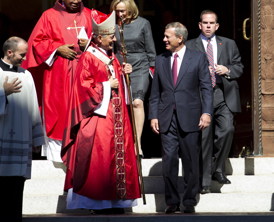 Cardinal Donald Wuerl, Archbishop of Washington, speaks with U.S. Supreme Court Chief Justice John Roberts as they leave St. Mathews Cathedral after the Red Mass in Washington on Sunday. The Supreme Court’s new term starts Monday.