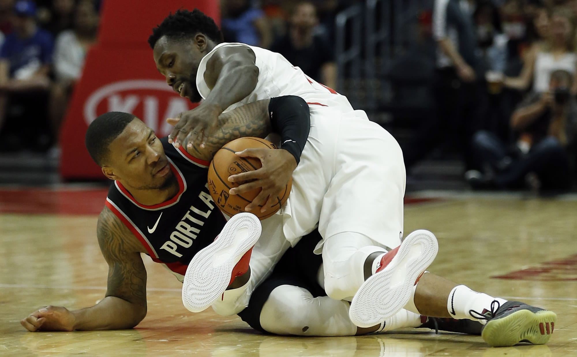 Portland Trail Blazers guard Damian Lillard, left, grabs the ball, competing with Los Angeles Clippers guard Patrick Beverley, right, during the second half of a preseason NBA basketball game in Los Angeles, Sunday, Oct. 8, 2017.