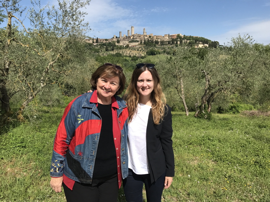 In this May 11, 2017 photo, Associated Press writer Courtney Bonnell, right, and her mother, Cathy Bonnell, pose in front of a view of San Gimignano, Italy. When taking a parent to Tuscany, a private tour helps get visitors to the scenic towns found off winding countryside roads.