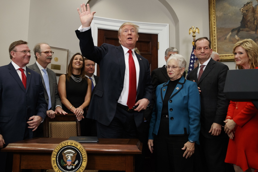 President Donald Trump waves after signing an executive order on health care in the Roosevelt Room of the White House, Thursday, Oct. 12, 2017, in Washington.