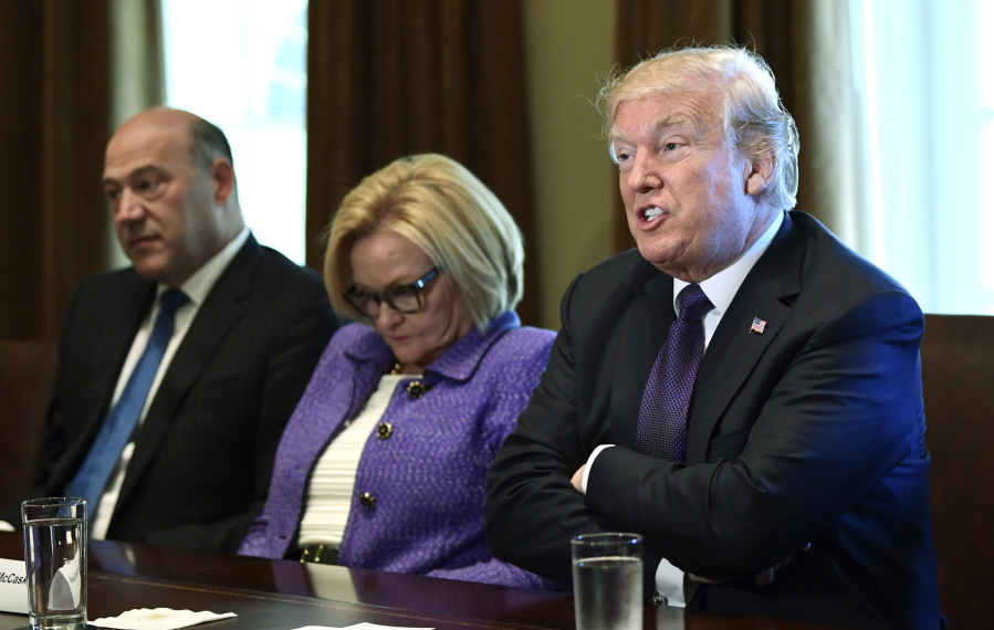 President Donald Trump, right, sits next to Sen. Claire McCaskill, D-Mo., center, and White House chief economic director Gary Cohn, left, during a meeting Wednesday at the White House in Washington.
