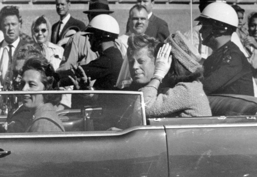 FILE - In this Nov. 22, 1963 file photo, President John F. Kennedy waves from his car in a motorcade in Dallas. Riding with Kennedy are First Lady Jacqueline Kennedy, right, Nellie Connally, second from left, and her husband, Texas Gov. John Connally, far left. President Donald Trump, on Saturday, Oct. 21, 2017, says he plans to release thousands of never-seen government documents related to President John F. Kennedy's assassination.