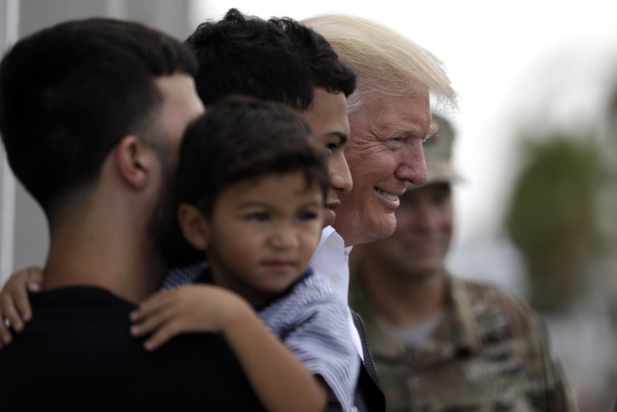 President Donald Trump poses for a photo as he visits a disaster relief distribution center at Calgary Chapel in Guaynabo, Puerto Rico, on Tuesday.