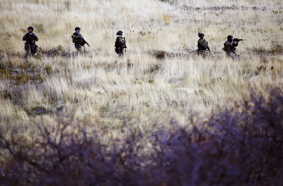 Law enforcement personnel comb the hills near the mouth of Red Butte Canyon in Salt Lake City on Tuesday, Oct. 31, 2017, in search of the gunman responsible for the shooting a University of Utah student during a fatal carjacking attempt near the University of Utah late Monday.
