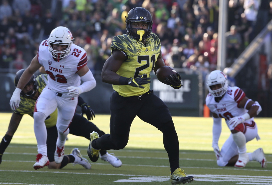 Oregon running back Royce Freeman rushes against Utah's Chase Hansen, left, and Sunia Tauteoli during the second quarter of an NCAA college football game Saturday, Oct. 28, 2017, in Eugene, Ore.