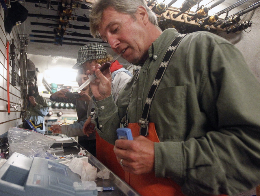 Massachusetts shark expert Greg Skomal pulls the cap off a shark blood sample for analysis in 2012 aboard the research vessel Ocearch.