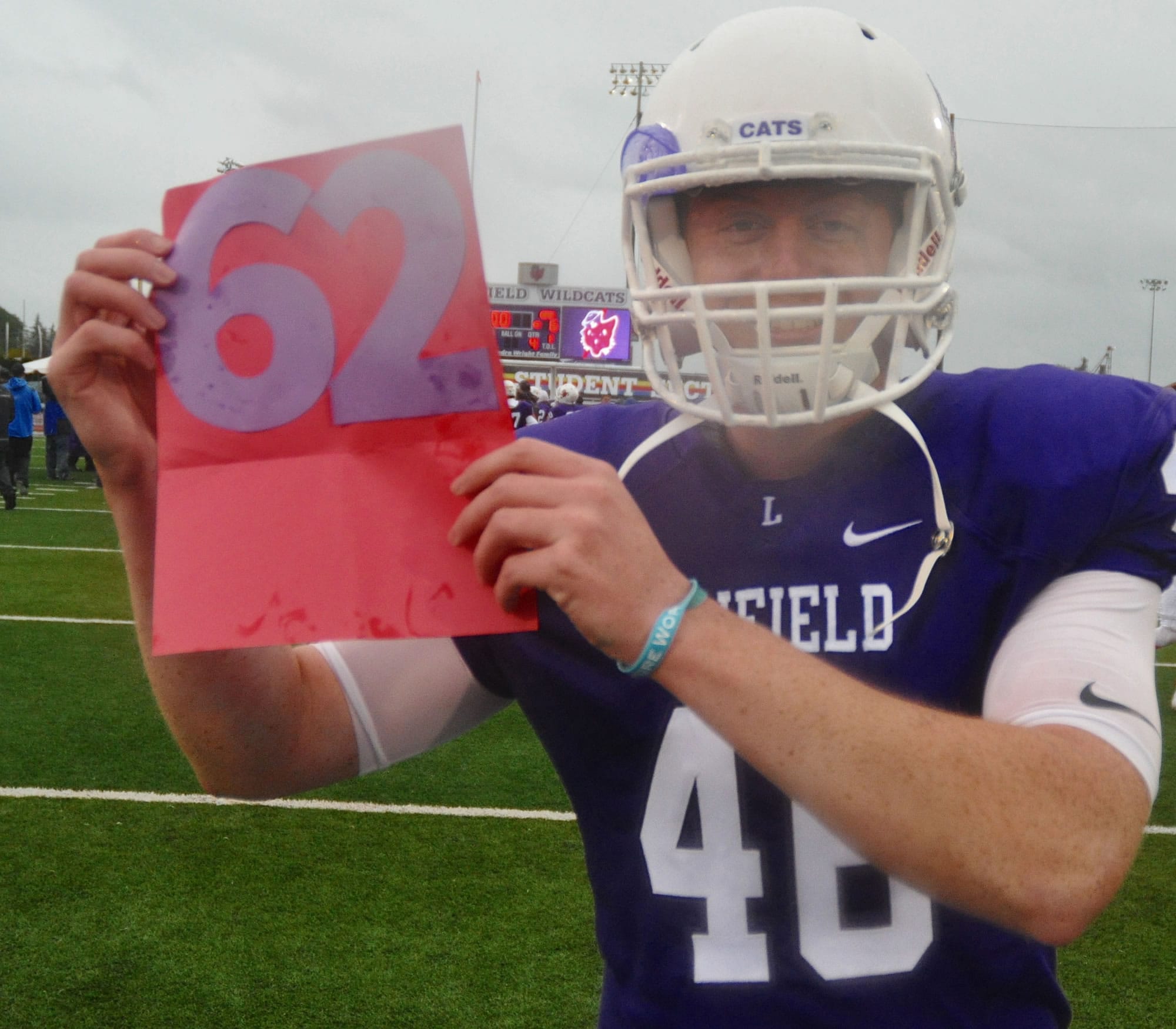 Linfield kicker Willy Warne holds a sign signifying the football program's 62nd consecutive winning season. Warne, a Mountain View High grad, made four field goals in a 12-6 win over George Fox on Saturday, Oct. 21.