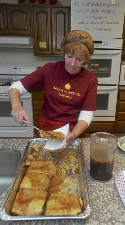Cheri Bradford dishes up a slice of apple pie at the annual apple festival at Riverside Christian School in Washougal last year.