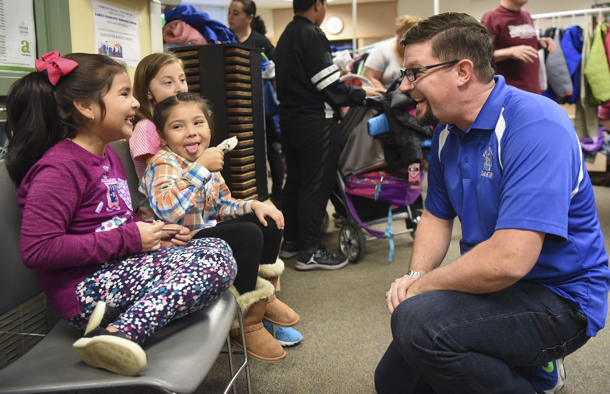 Fruit Valley Principal Matthew Fechter, right, talks to Emily Fargas, 6, from left, Arlet Aparicio, 5, and Giselle Betancourt, 9, while they eat ice cream Oct. 27 at the annual Fall Festival held at Fruit Valley Community Learning Center.