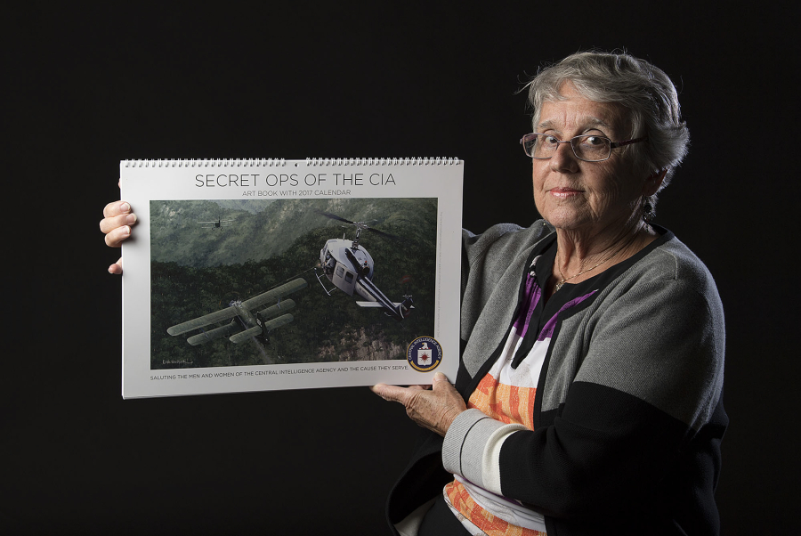 Ann Holland holds a 2017 calendar — “Secret Ops of the CIA” — that represents the place where her husband’s unit was overrun in 1968 during the Vietnam War. Mel Holland was on a mountaintop radar station that guided B-52 bombers toward targets in North Vietnam.