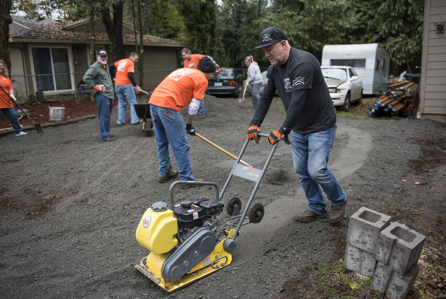 Kleen Street’s Joseph Wild-Talbott and Home Depot volunteers spread gravel at a home in Vancouver.