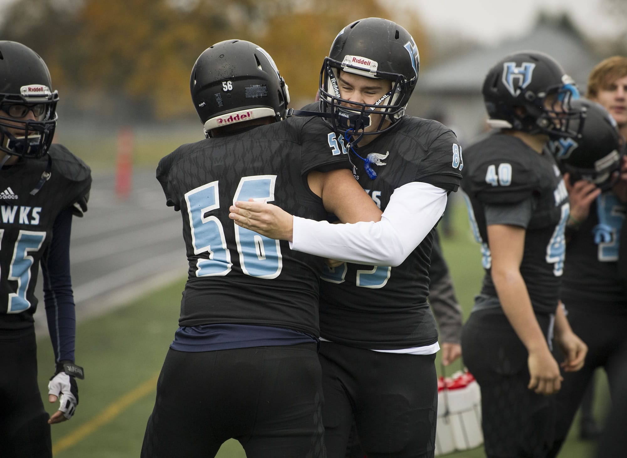 Hockinson’s Robert Flores (56) and Ki Haden (89) hug each other following a touchdown during the class 2A state playoffs against Pullman at Battle Ground District Stadium, Friday November 10, 2017.